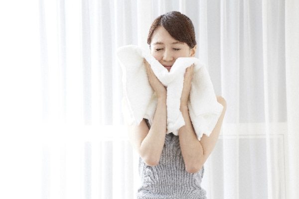 タオルで顔を拭いている女性