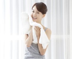 洗顔後に顔をタオルで拭いている女性